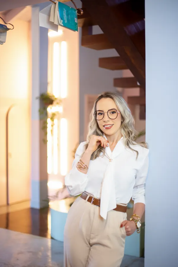 Daniela Bézi em pé, apoiada em uma parede